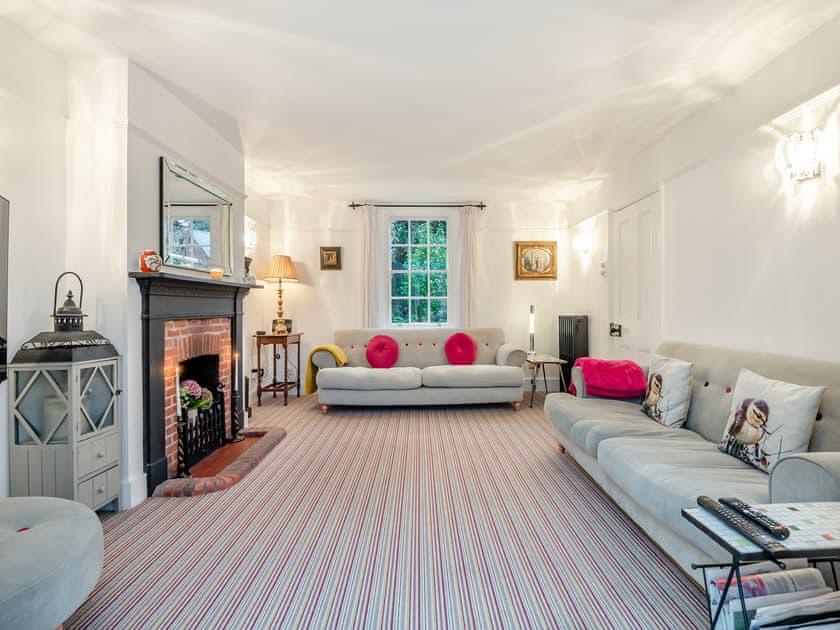 Bright living room with two facing sofas, a fireplace and a large bay window