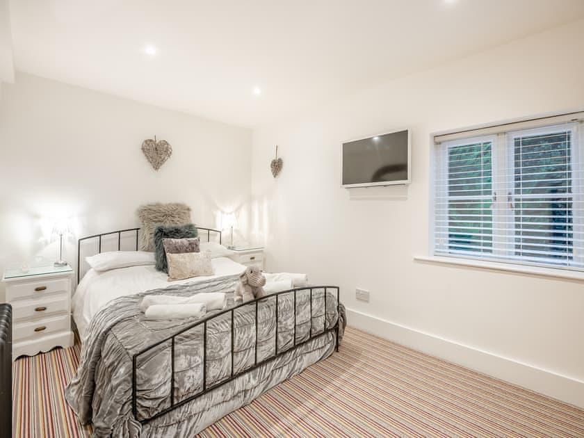 Bedroom four, with a silver upholstered bed frame and coastal wall decoration